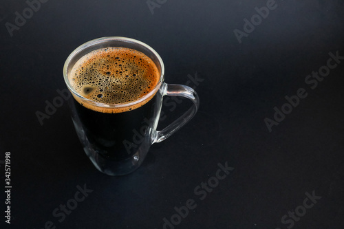 Transparent cup of coffee on a black background