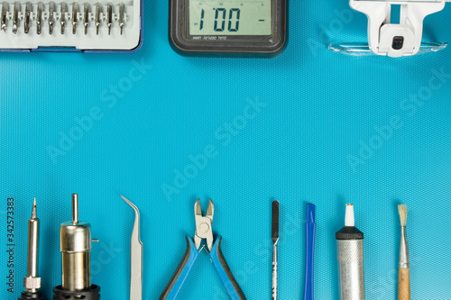 Tools for repairing phones, tablets and electronic equipment with copy space on a blue background. Top view, flat lay