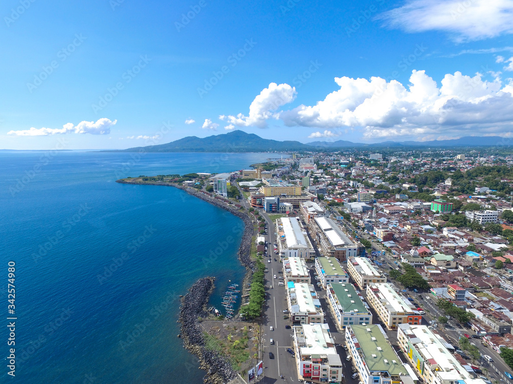 Manado Indonesia June 28, 2020 : Aerial skyscrapers marina in the sunny day with front line of office, home, urban city Manado Indonesia