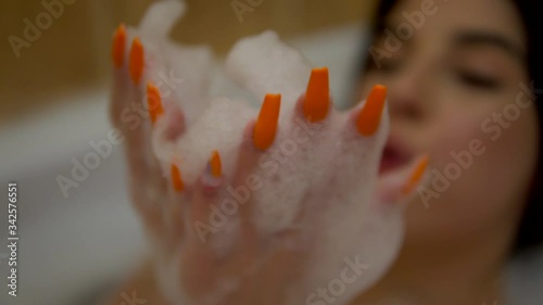 beauty girl playing with foam in bubble bath, relaxing at home, cozy bathroom photo