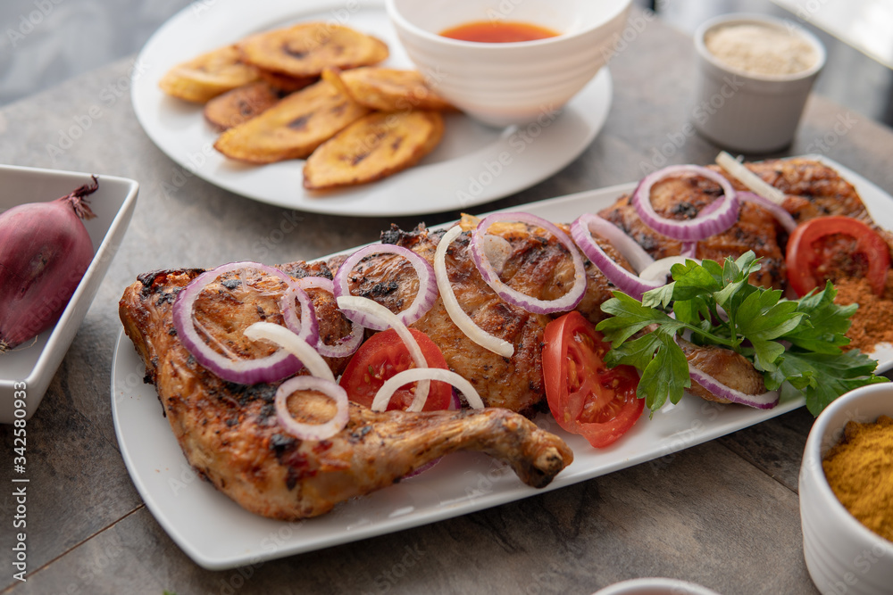 Grilled chicken with red onions. African food meal. Nigerian national dish. Fresh and healthy with tomatoes and red onions. Fried food. Fresh salad with peppers Cuisine Grilled chicken with red onions. African food meal. Nigerian national dish. Fresh and healthy with tomatoes and red onions. Fried food. Fresh salad with peppers Cuisine