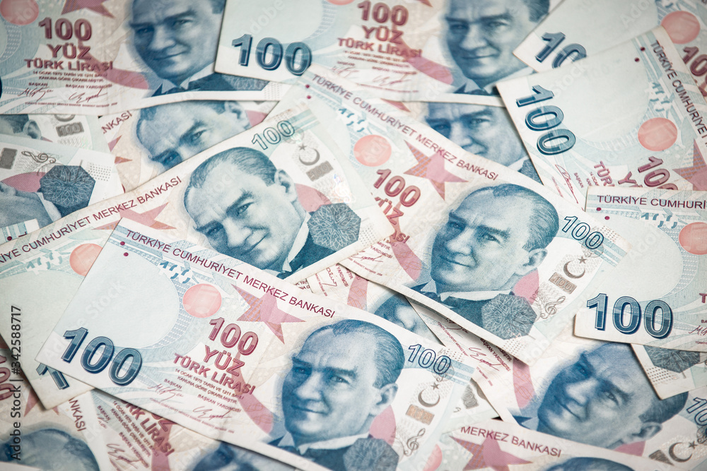 Obraz premium Many hundred Turkish lira on wooden table background texture. bundles of money scattered on the office desk. wealth and income concept. Counting money. 