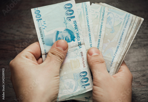 Many hundred Turkish lira on wooden table background texture. bundles of money scattered on the office desk. wealth and income concept. Counting money. 