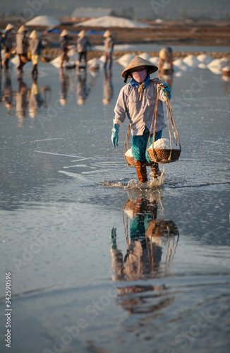 Salt and Silhoutte of salt farmer on salt field Hon Khoi, Nha Trang, Khanh Ho...