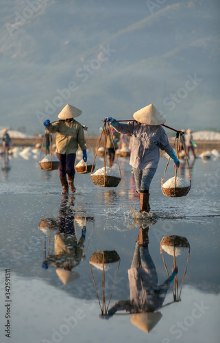 Salt and Silhoutte of salt farmer on salt field Hon Khoi, Nha Trang, Khanh Ho...