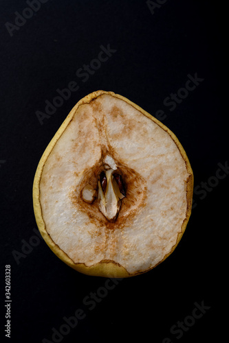 cut out section of an overripe pear on black background