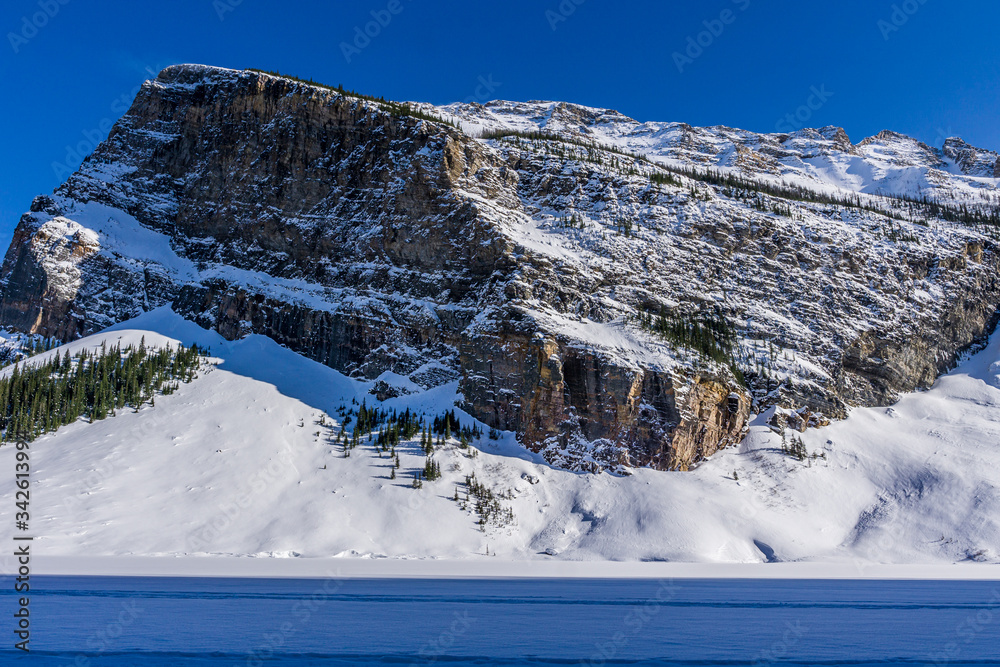 rocky mountains around frozen lake louise winter wonderland.