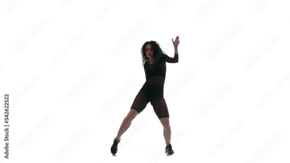 young beautiful woman in a black transparent tight suit energetically dancing dancehall, street dance, twerk against white background, isolated young beautiful woman in a black transparent tight suit energetically dancing dancehall, street dance, twerk against white background, isolated
