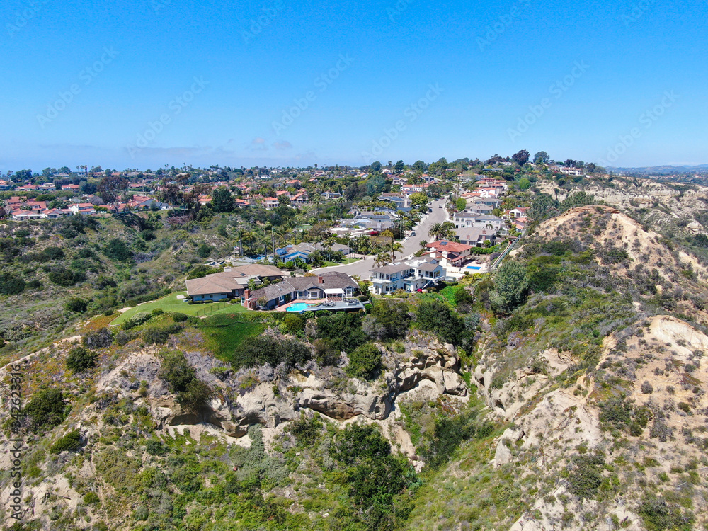 Aerial view of upper middle class neighborhood with residential house and swimming pool in a valley in San Diego, California, USA.
