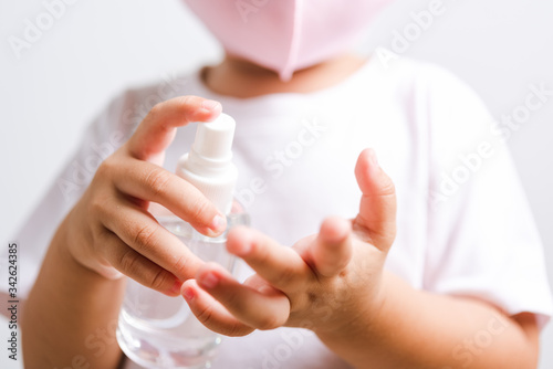 Closeup portrait Asian little child boy holding show bottle pump dispenser sanitizer alcohol spray hand wash cleaning  COVID-19 or coronavirus protection concept  isolated on white background