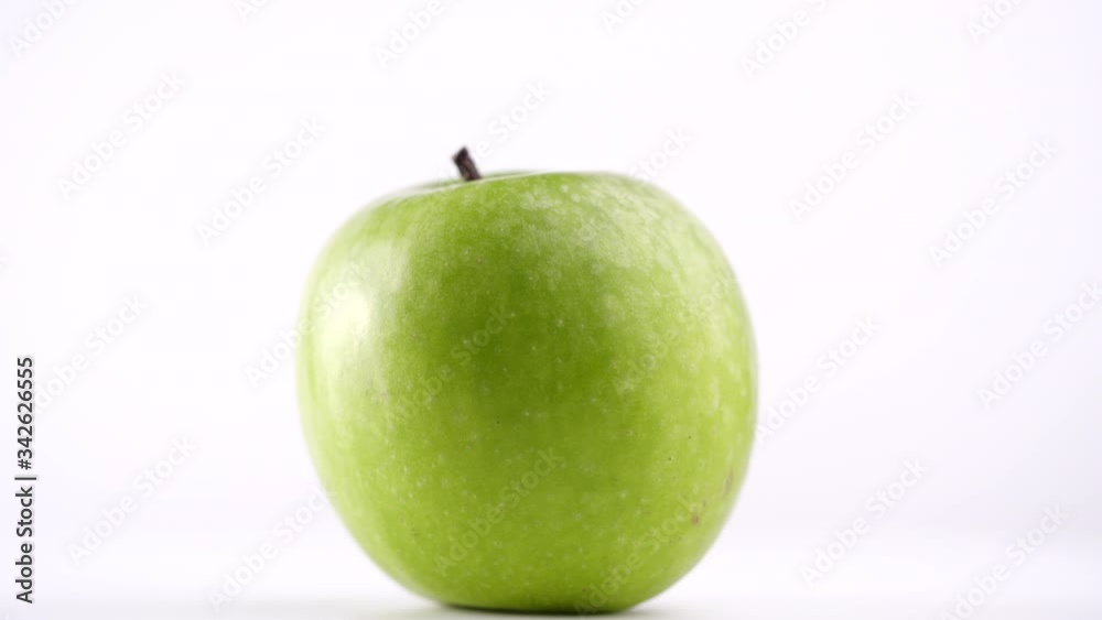 Close-up of fresh green apple rotating on white background in 4K resolution Close-up of fresh green apple rotating on white background in 4K resolution