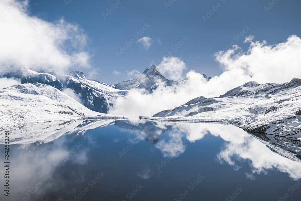Jungfrau region. Top of Europe. Place for tourist attraction to to visit in Switzerland, hiking in snow mountains. Swiss alps is reflecting in blue Bachalpsee lake. Destination for traveler and hiker
