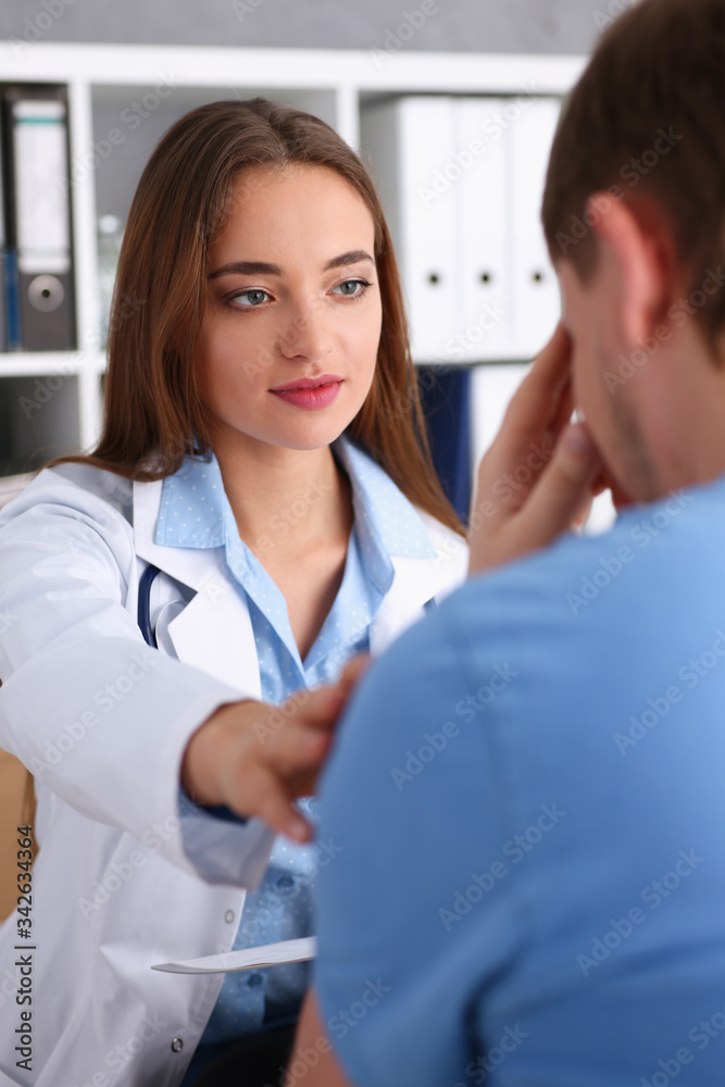 Fototapeta premium Friendly female doctor hold patient shoulder in office during reception portrait. Examination result cheer up for grief condolence and suffer calm down promise or test treatment ethics concept