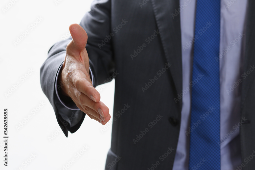 Man in suit and tie give hand as hello in office closeup. Friend welcome mediation offer positive introduction thanks gesture summit participate approval motivation male arm strike bargain