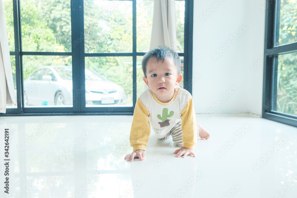 Little asian boy crawling on floor in cozy home Little asian boy crawling on floor in cozy home