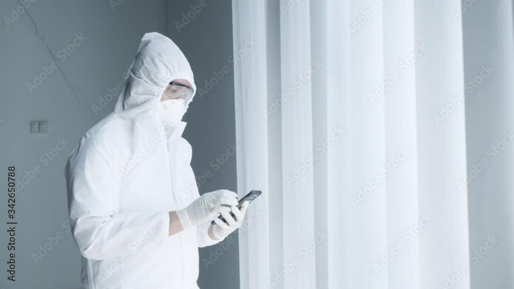 Doctor wear hazmat suit and using mobile phone Doctor wear hazmat suit and using mobile phone