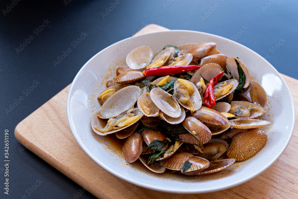 Delicious stir fried clams with chili paste on white plate.Thai food. Delicious stir fried clams with chili paste on white plate.Thai food.