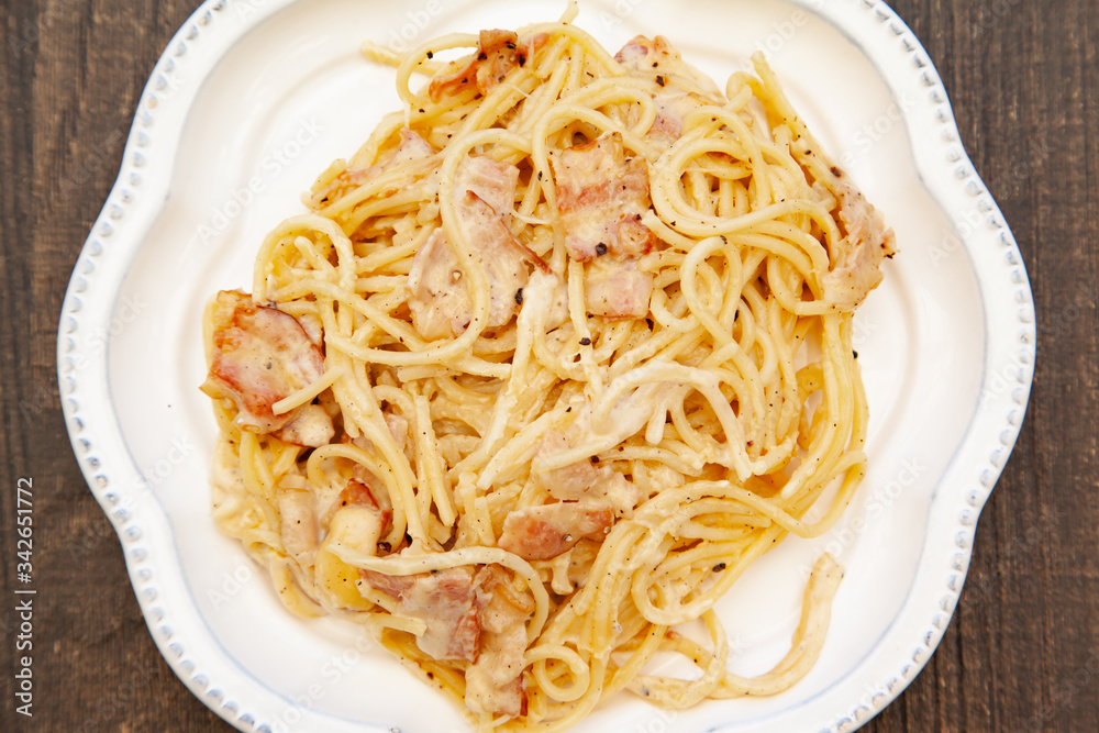 Carbonara pasta, spaghetti with pancetta, egg, hard parmesan cheese and cream sauce. Traditional italian cuisine