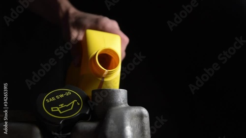 Filling engine oil from a yellow canister into the cylinder block