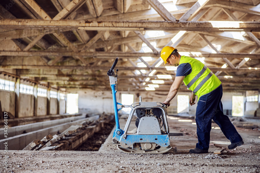 Fototapeta premium Full length of construction worker using machine.