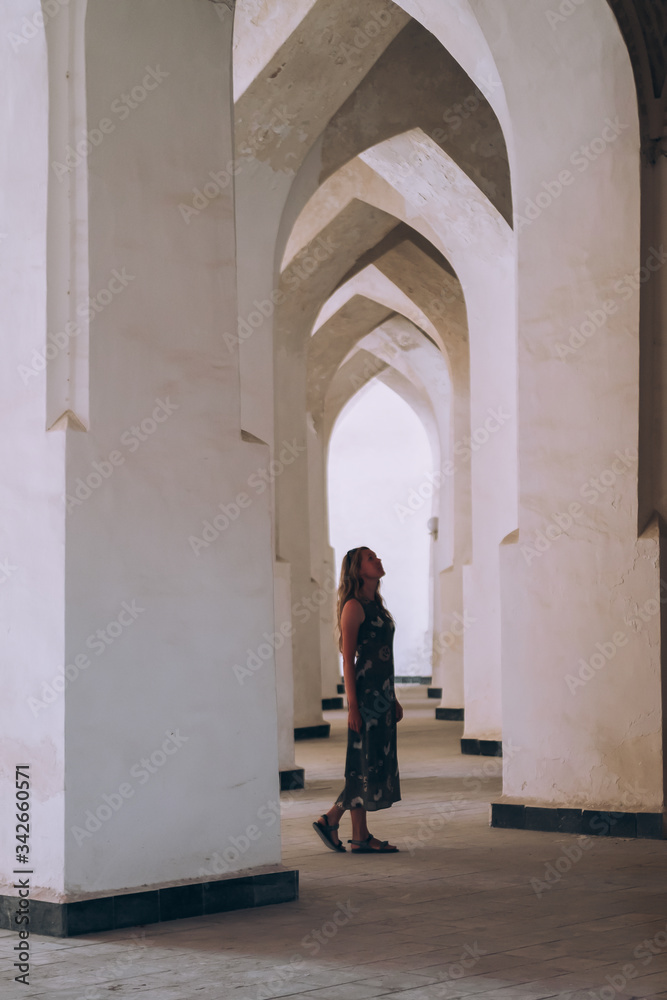 Middle Asia. Uzbekistan Bukhara. white arched openings create a corridor. A girl is standing among them. Girl and buildings.