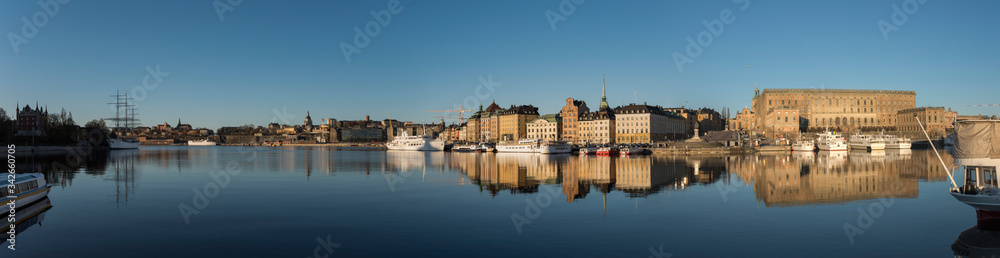 A sunny early day in Stockholm, view over piers with boats and birds at the old town Gamla Stan district 