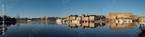 A sunny early day in Stockholm, view over piers with boats and birds at the old town Gamla Stan district 