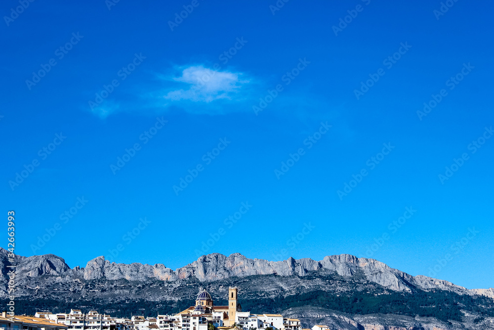 landscape with spanish resort town at foot of mountain, background with nature and architecture