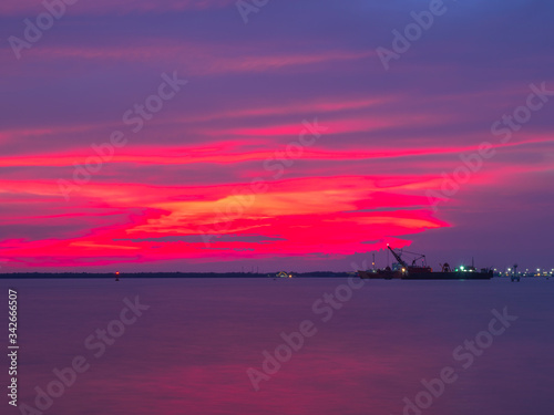 A cargo ship is sailing in the Gulf of Thailand in the twilight  hour.