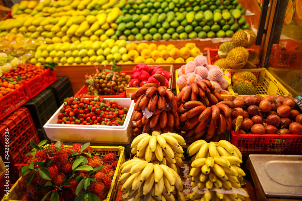 Bananas, strawberries, mangoes on the counter in the market.