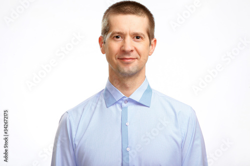 A happy man in a light shirt smiles, stares at the camera. Isolated