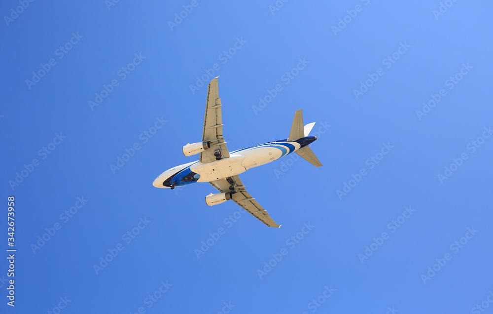Airplane flying under blue sky. Seen from below. Airplane flying under blue sky. Seen from below.