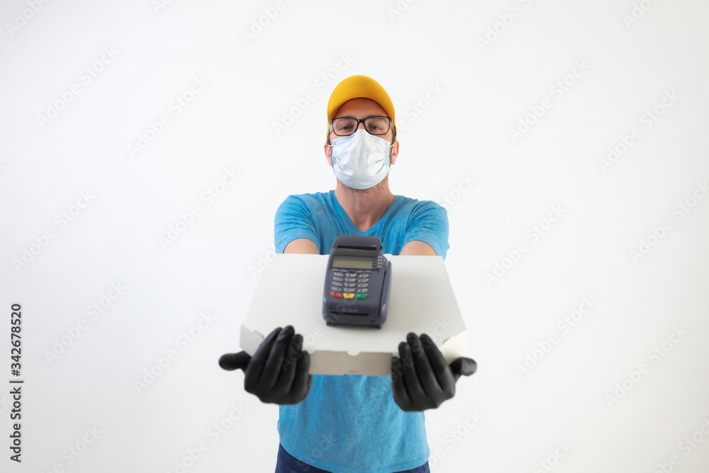 Delivery guy with protective mask holding pizza box and POS for contactless payment. Delivery guy with protective mask holding pizza box and POS for contactless payment.