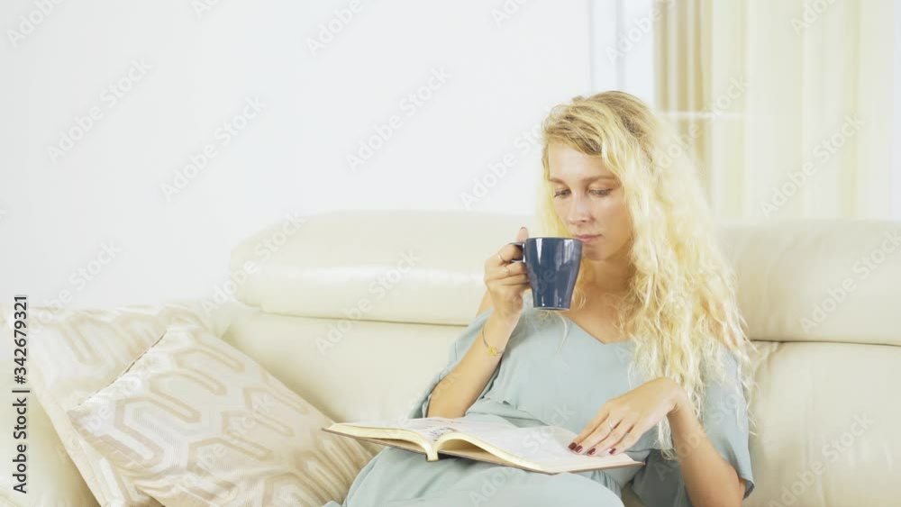Blonde woman reads book and drinks coffee Blonde woman reads book and drinks coffee