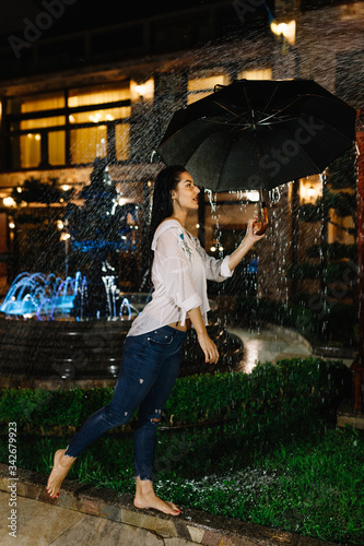 Laughing woman with umbrella checking for rain