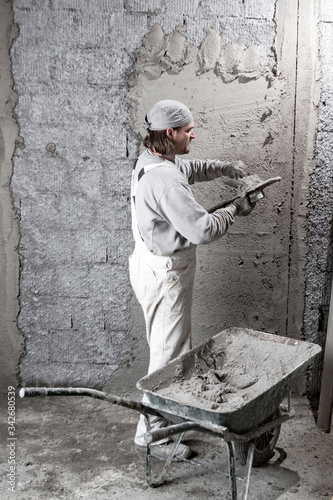 Real construction worker making a wall inside the new house.