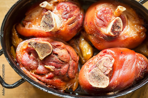 Photography Roasted pork knuckle with onions in beer