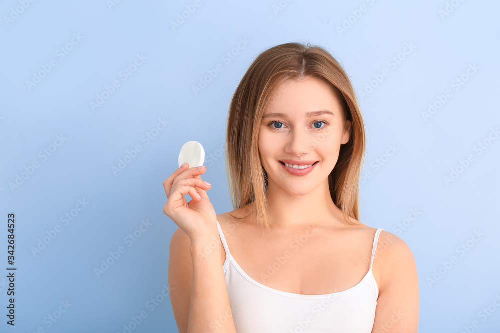 Beautiful young woman with cotton pad on color background Beautiful young woman with cotton pad on color background