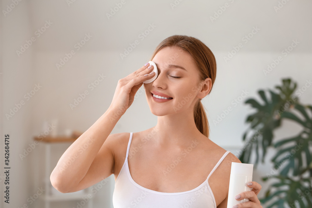 Beautiful young woman removing makeup at home Beautiful young woman removing makeup at home