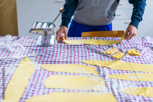 teenage boy make tagliatelle homemade at home in quarantine period