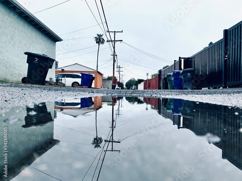 Telephone pole reflection over water in alleyway  
