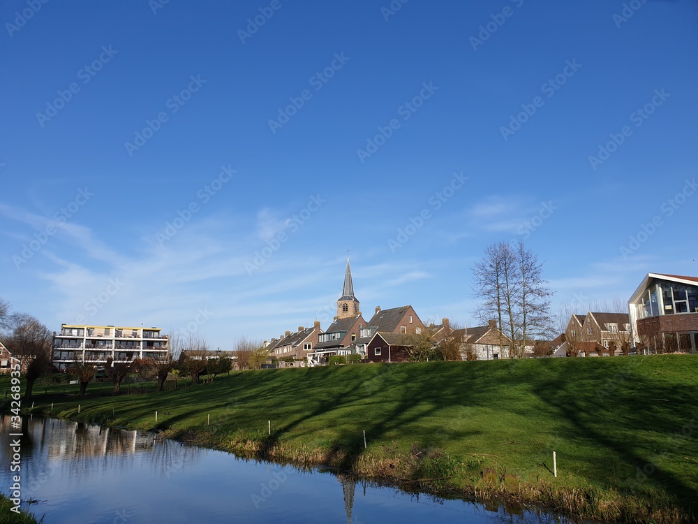 Old village with church on a mound in Nieuwerkerk aan den Ijssel with blue sky