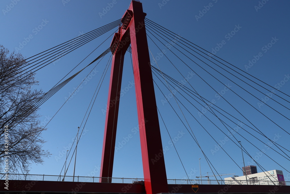 Steel bridge in red color called Willemsbrug in the center of Rotterdam over the Nieuwe Maas river in the Netherlands Steel bridge in red color called Willemsbrug in the center of Rotterdam over the Nieuwe Maas river in the Netherlands