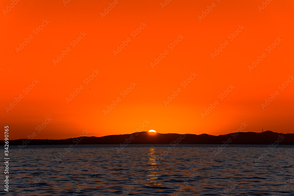 Beautiful orange sky with sunset over the sea, landscape from the beach in Zadar, Dalmatia, Croatia, Europe