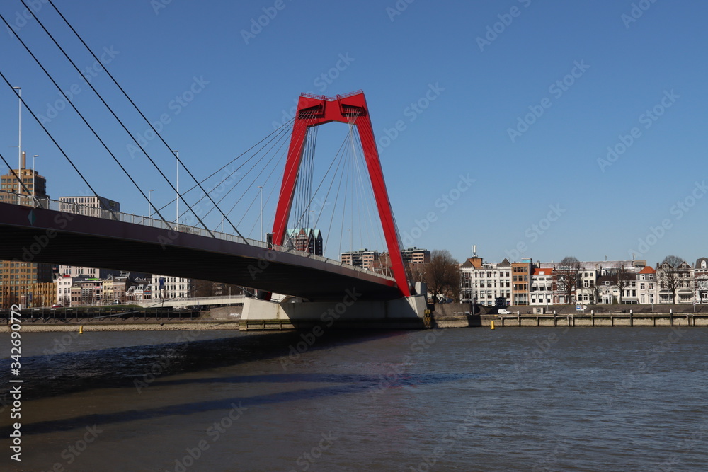 Steel bridge in red color called Willemsbrug in the center of Rotterdam over the Nieuwe Maas river in the Netherlands