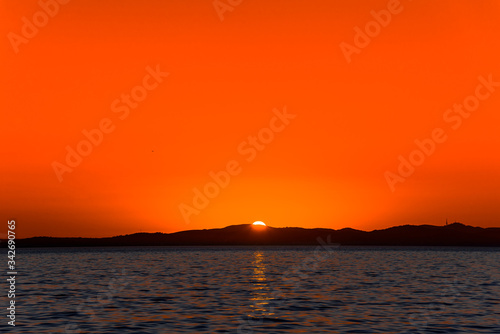 Beautiful orange sky with sunset over the sea, landscape from the beach in Zadar, Dalmatia, Croatia, Europe