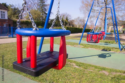 Empty swings in children's playground in England during lockdown due to coronavirus quarantine for the prevention of COVID-19.