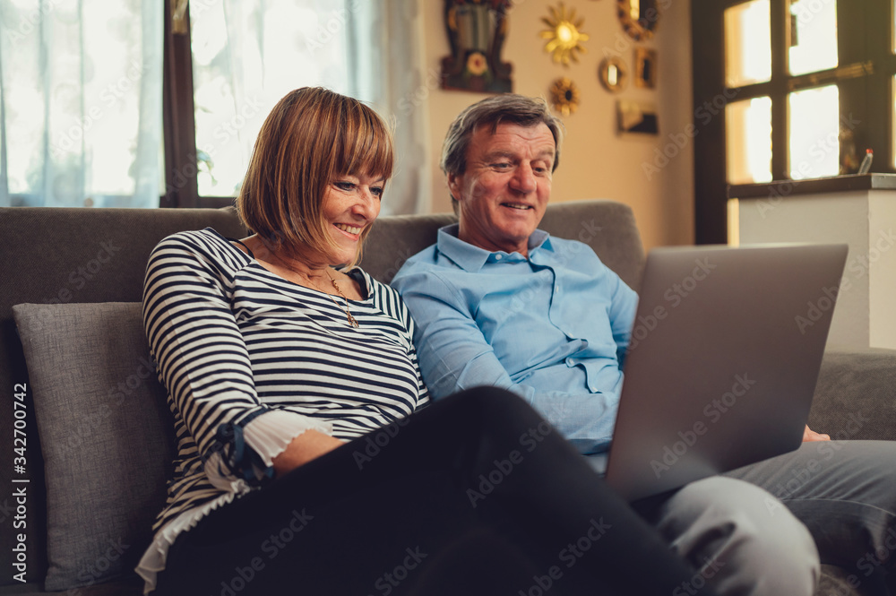 Coppia di europei di mezza età realizza una video chiamata con la famiglia. Tablet, laptop, smartphone. Distanza sociale e tecnologia 