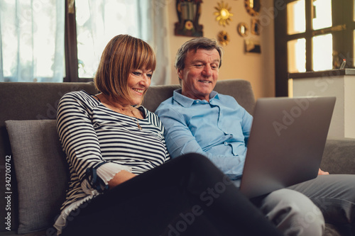 Coppia di europei di mezza età realizza una video chiamata con la famiglia. Tablet, laptop, smartphone. Distanza sociale e tecnologia 