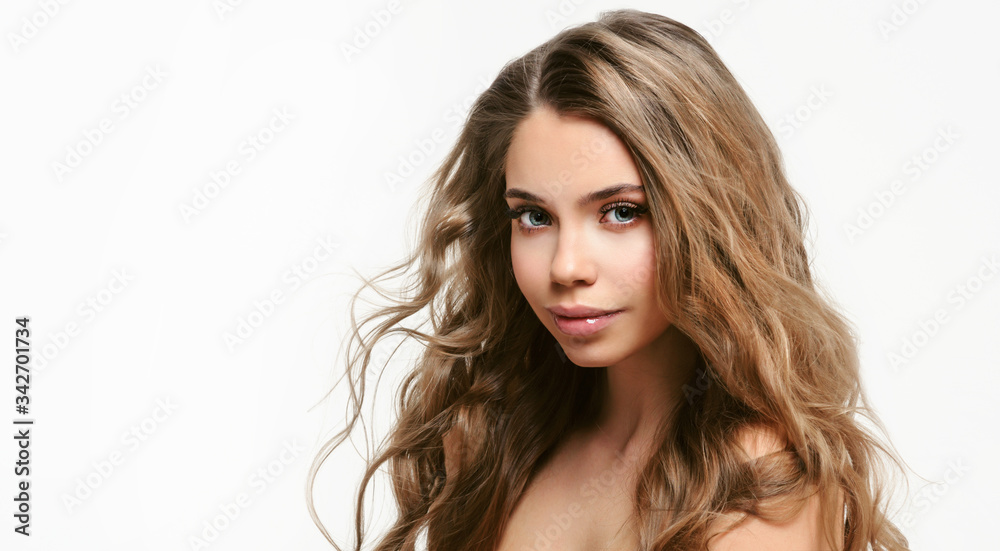 Portrait of young beautiful woman isolated at white background. Blonde girl with long and shiny wavy hair . Smiling friendly girl with curly hairstyle Portrait of young beautiful woman isolated at white background. Blonde girl with long and shiny wavy hair . Smiling friendly girl with curly hairstyle
